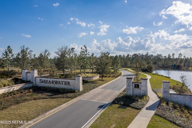 surrounding community featuring a water view and a lawn