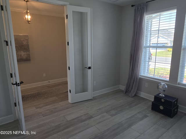 unfurnished bedroom featuring baseboards, wood finished floors, and ornamental molding