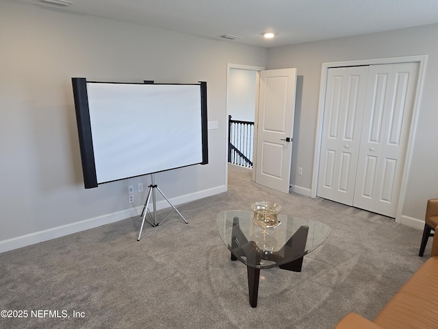 carpeted cinema room featuring visible vents and baseboards