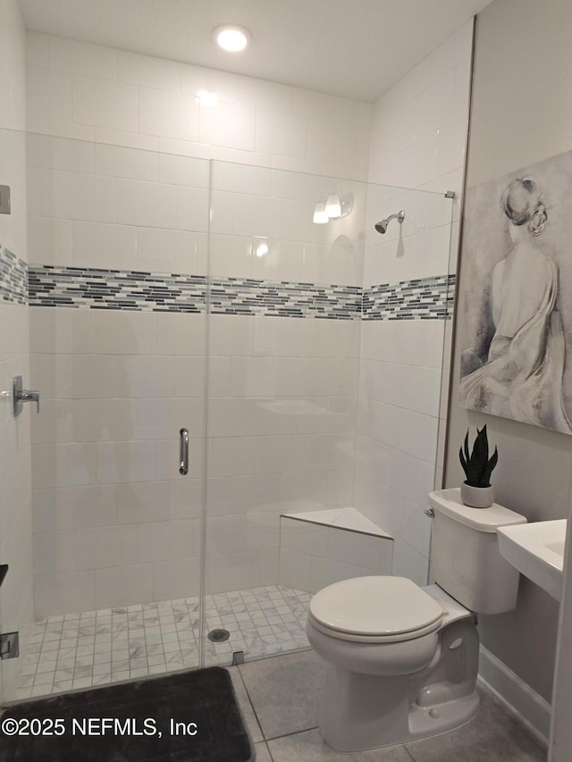 bathroom with tile patterned flooring, a shower stall, and toilet