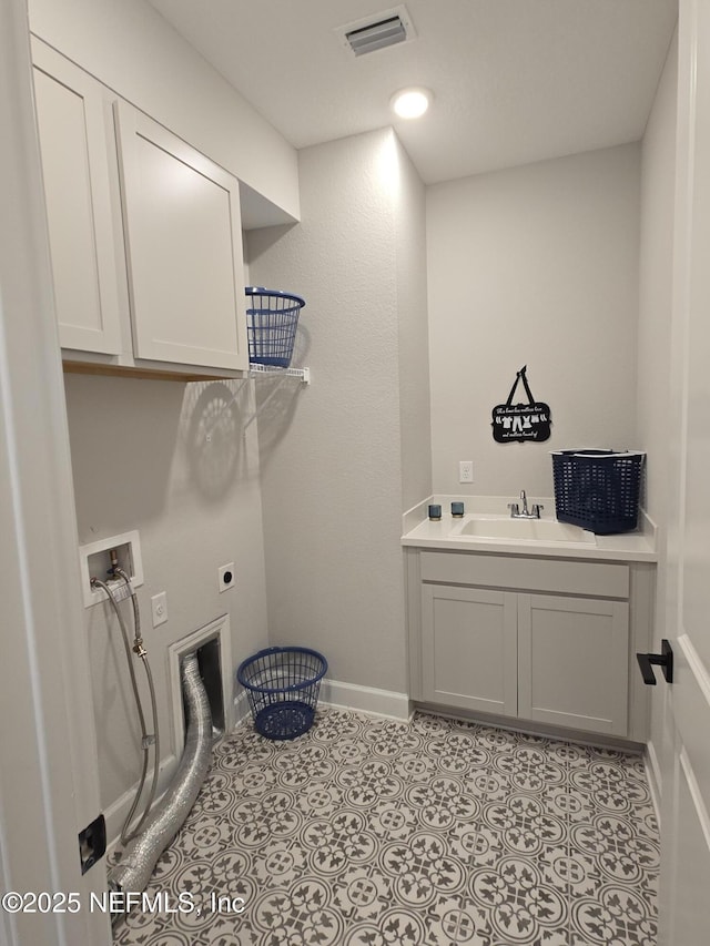 laundry room featuring visible vents, light tile patterned flooring, cabinet space, electric dryer hookup, and a sink