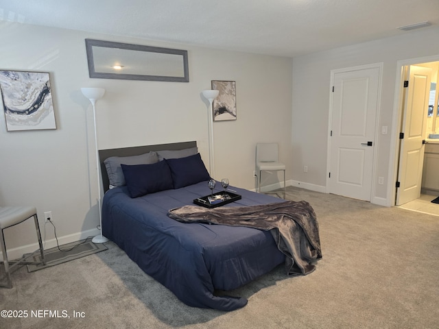 carpeted bedroom featuring baseboards and connected bathroom