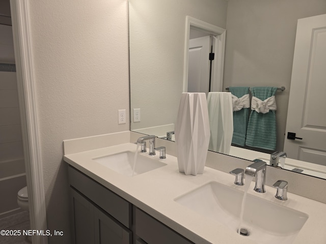 full bathroom featuring double vanity, toilet, and a sink