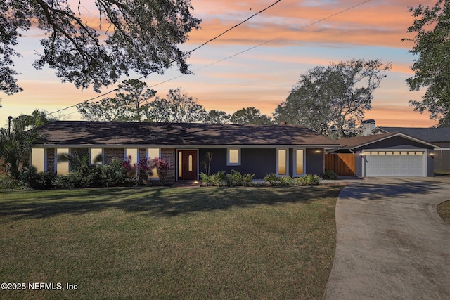 single story home with a garage and a lawn