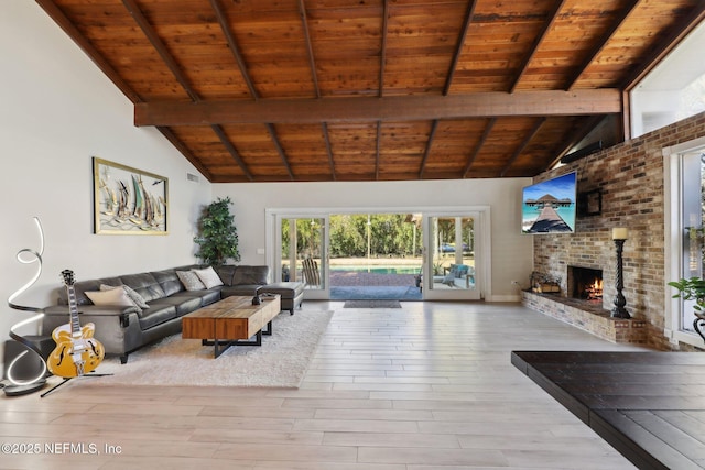 unfurnished living room with a fireplace, beam ceiling, light hardwood / wood-style floors, and wooden ceiling