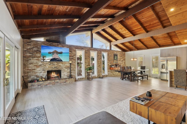 living room featuring a brick fireplace, light hardwood / wood-style flooring, wooden ceiling, and brick wall