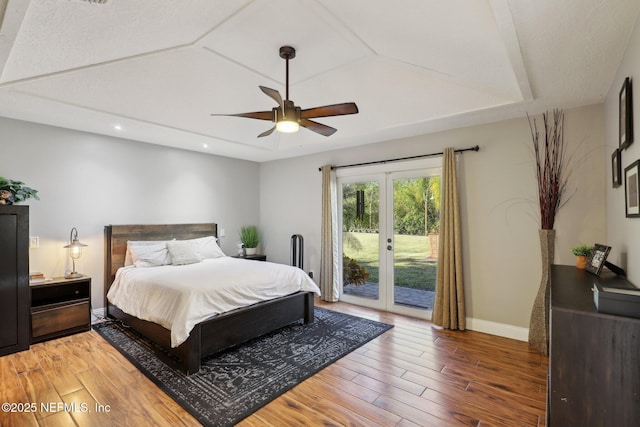 bedroom featuring a raised ceiling, access to exterior, french doors, and ceiling fan