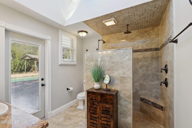 bathroom featuring toilet and a tile shower