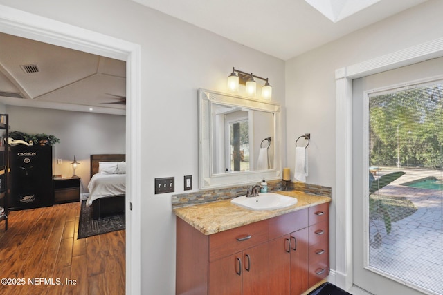 bathroom featuring vanity, a skylight, and wood-type flooring