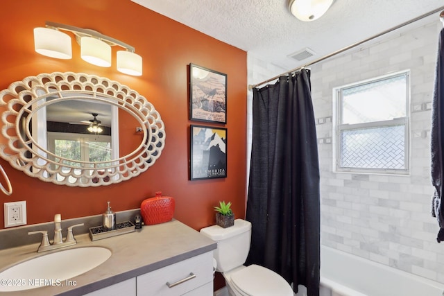 full bathroom featuring vanity, ceiling fan, toilet, shower / bathtub combination with curtain, and a textured ceiling