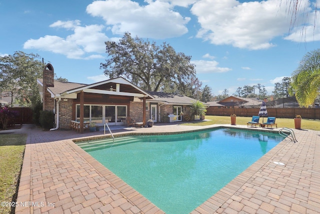 view of pool featuring a lawn and a patio