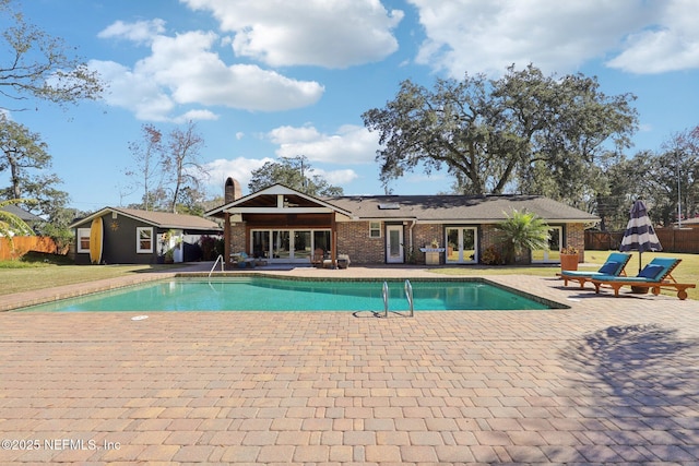 view of swimming pool with a yard, an outbuilding, and a patio