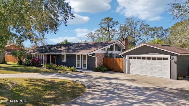 ranch-style home featuring a garage and a front lawn