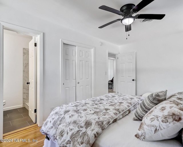 bedroom with ensuite bath, wood-type flooring, a closet, and ceiling fan