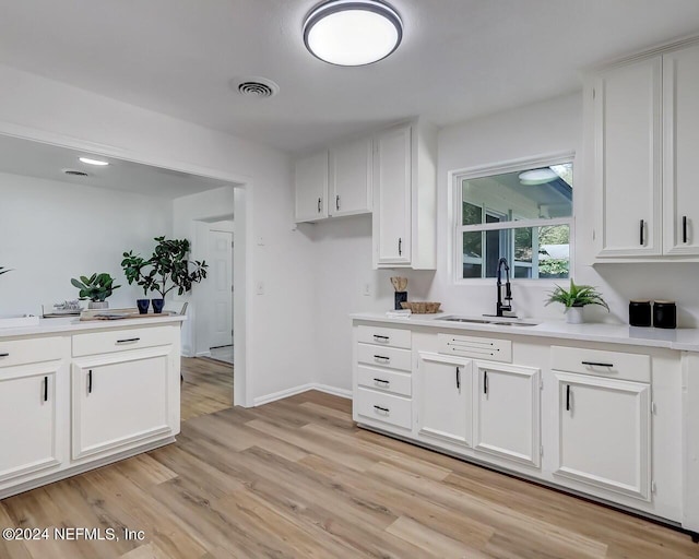 kitchen featuring light hardwood / wood-style floors, sink, and white cabinets