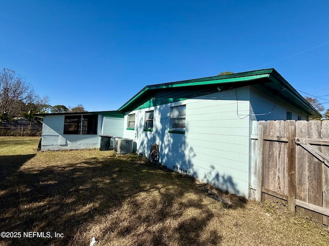 view of home's exterior featuring central AC and a yard