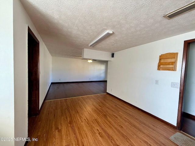 empty room with hardwood / wood-style floors and a textured ceiling