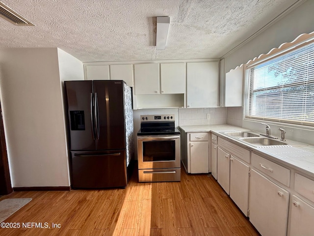 kitchen with stainless steel electric range, white cabinetry, sink, and black refrigerator with ice dispenser