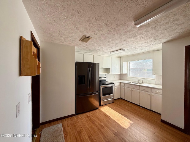 kitchen featuring electric stove, refrigerator with ice dispenser, light hardwood / wood-style flooring, and white cabinets