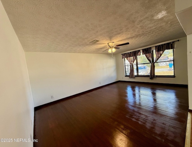 unfurnished room with dark wood-type flooring, ceiling fan, and a textured ceiling