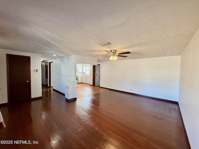 unfurnished room with dark wood-type flooring, ceiling fan, and a textured ceiling