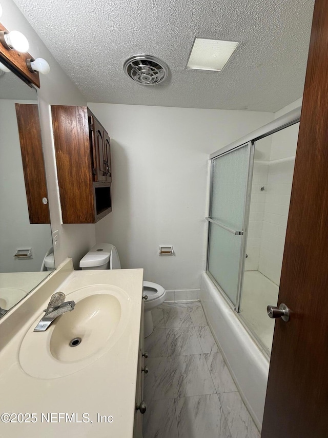 full bathroom with bath / shower combo with glass door, vanity, and toilet