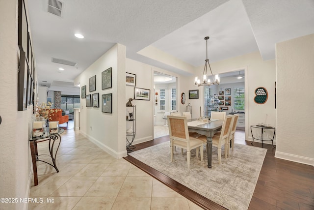 tiled dining space featuring a chandelier