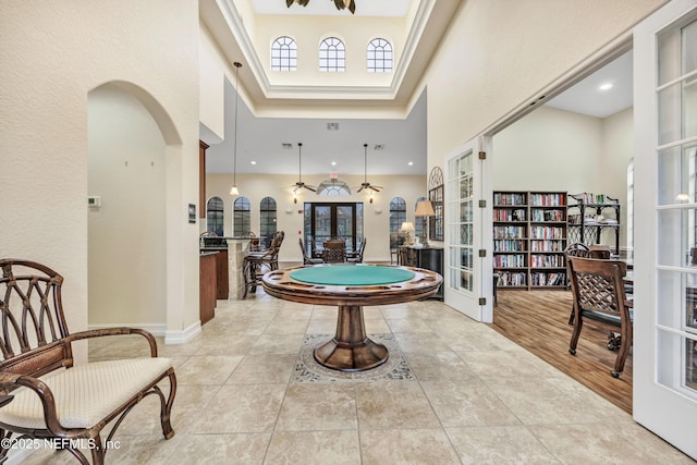 recreation room with french doors and a high ceiling