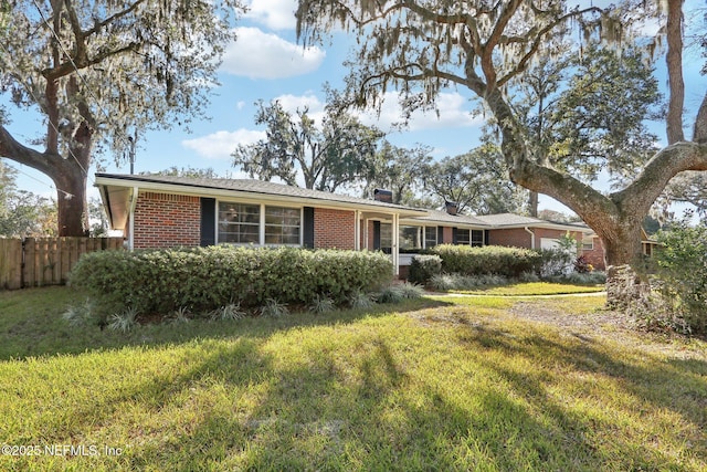 single story home with a front yard, fence, an attached garage, a chimney, and brick siding