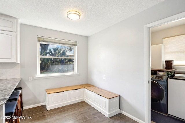 interior space featuring laundry area, washer / clothes dryer, baseboards, and wood finish floors