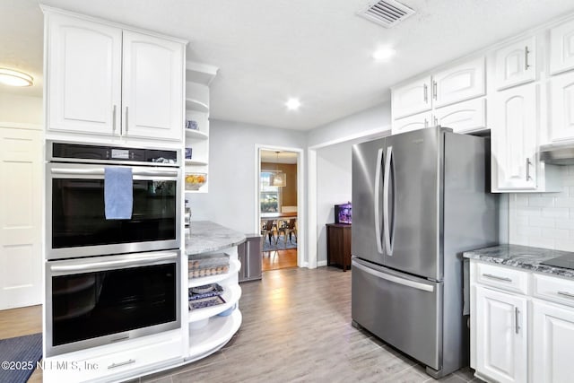 kitchen with visible vents, white cabinets, stainless steel appliances, and open shelves