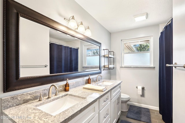 bathroom featuring a sink, plenty of natural light, and toilet