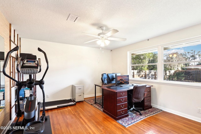 office area featuring baseboards, wood finished floors, visible vents, and a textured ceiling