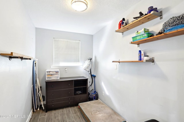 interior space featuring a textured ceiling and wood tiled floor