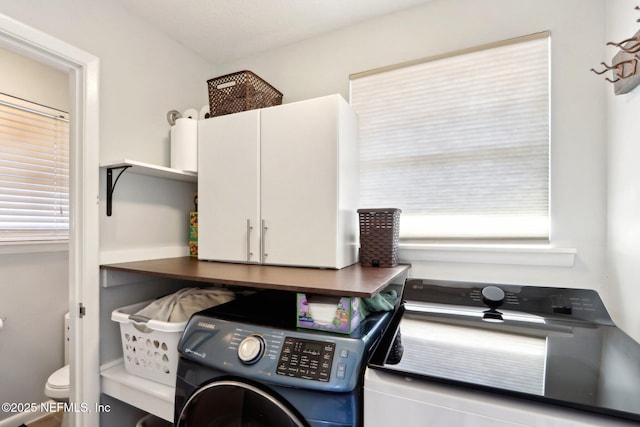 washroom featuring cabinet space and washer and dryer