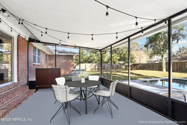 sunroom / solarium featuring rail lighting