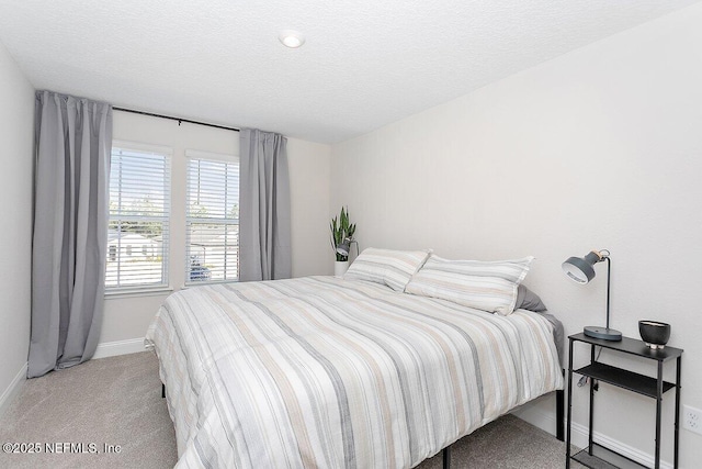 bedroom with light carpet and a textured ceiling