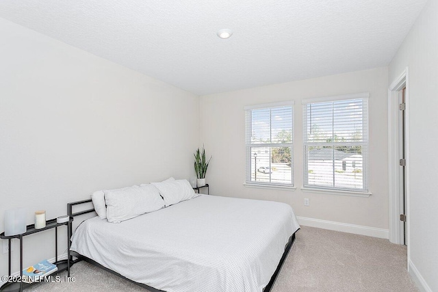 bedroom with light carpet and a textured ceiling