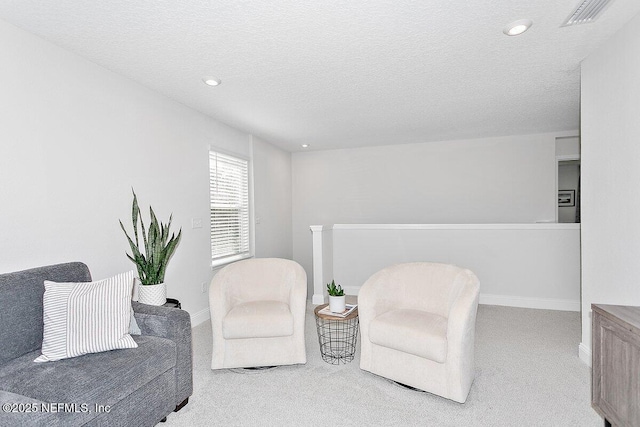 living area with carpet floors and a textured ceiling