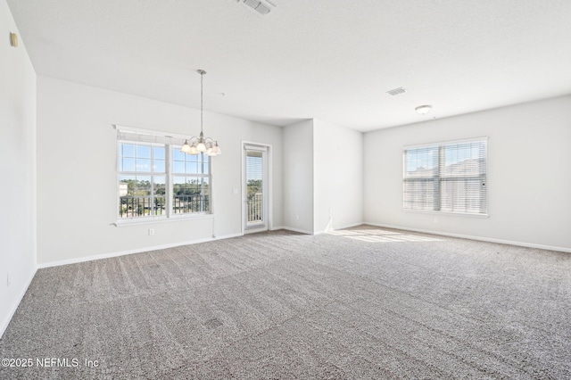 unfurnished room with a chandelier and carpet