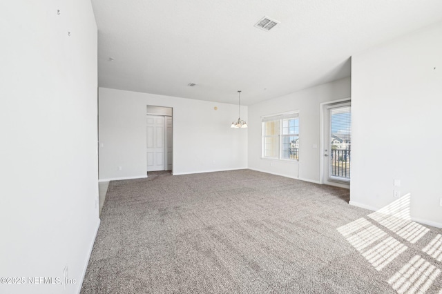 empty room with a notable chandelier and carpet