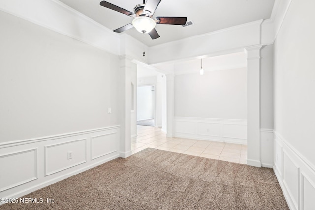 unfurnished room with decorative columns, ornamental molding, light colored carpet, and ceiling fan