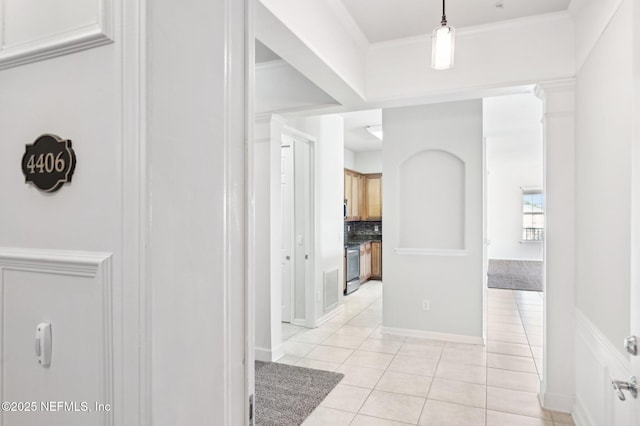 corridor with light tile patterned flooring and ornamental molding