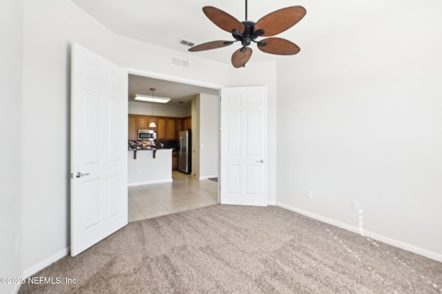 empty room featuring light colored carpet and ceiling fan