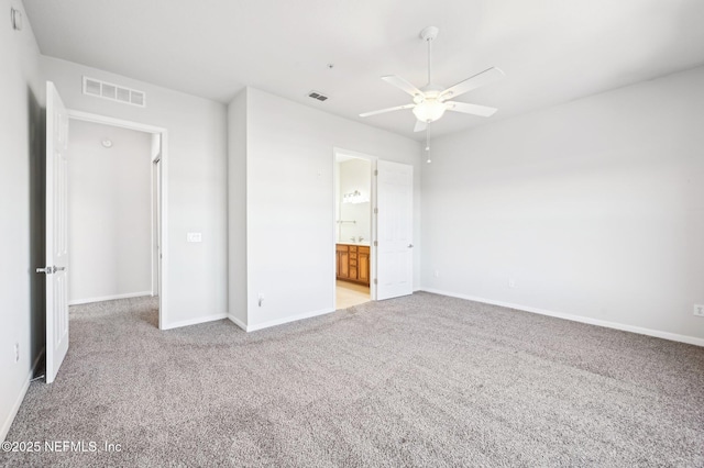 unfurnished bedroom featuring light carpet, ensuite bath, and ceiling fan