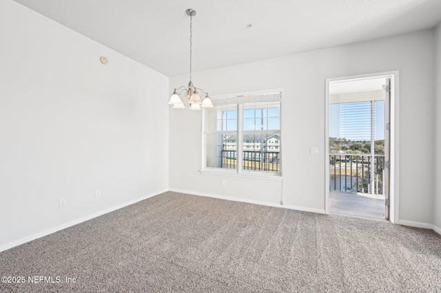 empty room featuring a notable chandelier and carpet floors