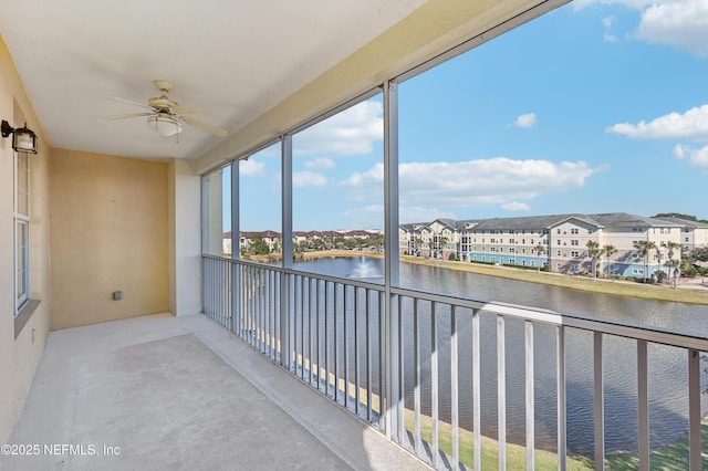 unfurnished sunroom with ceiling fan and a water view