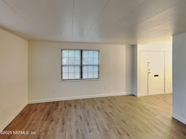 unfurnished room featuring a textured ceiling and light wood-type flooring