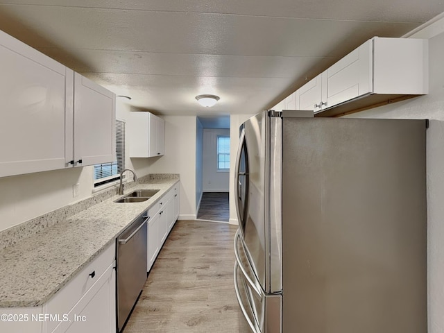 kitchen featuring white cabinetry, appliances with stainless steel finishes, sink, and light hardwood / wood-style flooring