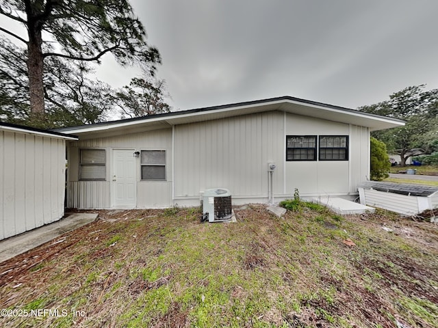 view of side of property featuring cooling unit and a yard